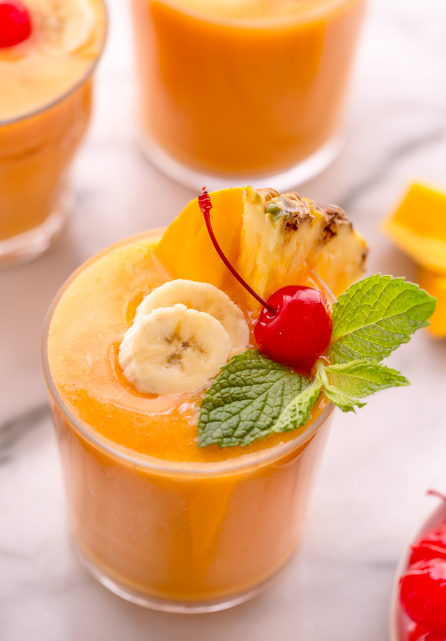 This refreshing tropical smoothie recipe is made with exotic fruit like mango, pineapple, and papaya! Ready in less than 5 minutes, this delicious and healthy treat is the perfect way to start your morning! Makes 2 smoothies, but can easily be double or tripled as needed! #tropicalsmoothie #fruitsmoothie #smoothies #smoothie #pineapplesmoothie #tropical