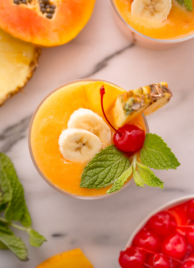 This refreshing tropical smoothie recipe is made with exotic fruit like mango, pineapple, and papaya! Ready in less than 5 minutes, this delicious and healthy treat is the perfect way to start your morning! Makes 2 smoothies, but can easily be double or tripled as needed! #tropicalsmoothie #fruitsmoothie #smoothies #smoothie #pineapplesmoothie #tropical