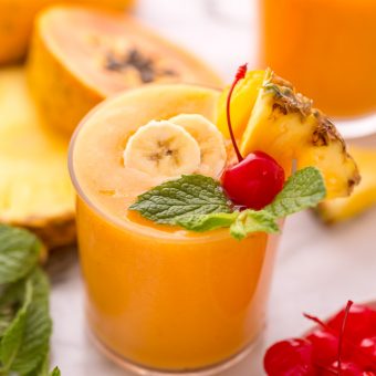 This refreshing tropical smoothie recipe is made with exotic fruit like mango, pineapple, and papaya! Ready in less than 5 minutes, this delicious and healthy treat is the perfect way to start your morning! Makes 2 smoothies, but can easily be double or tripled as needed! #tropicalsmoothie #fruitsmoothie #smoothies #smoothie #pineapplesmoothie #tropical