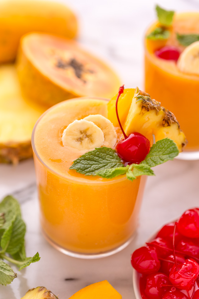 This refreshing tropical smoothie recipe is made with exotic fruit like mango, pineapple, and papaya! Ready in less than 5 minutes, this delicious and healthy treat is the perfect way to start your morning! Makes 2 smoothies, but can easily be double or tripled as needed! #tropicalsmoothie #fruitsmoothie #smoothies #smoothie #pineapplesmoothie #tropical