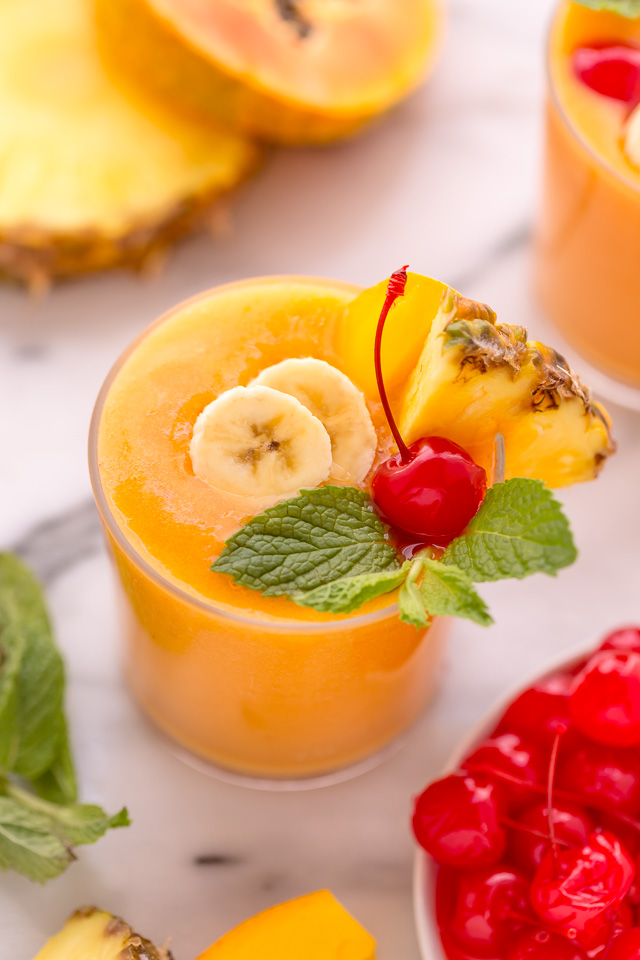This refreshing tropical smoothie recipe is made with exotic fruit like mango, pineapple, and papaya! Ready in less than 5 minutes, this delicious and healthy treat is the perfect way to start your morning! Makes 2 smoothies, but can easily be double or tripled as needed! #tropicalsmoothie #fruitsmoothie #smoothies #smoothie #pineapplesmoothie #tropical