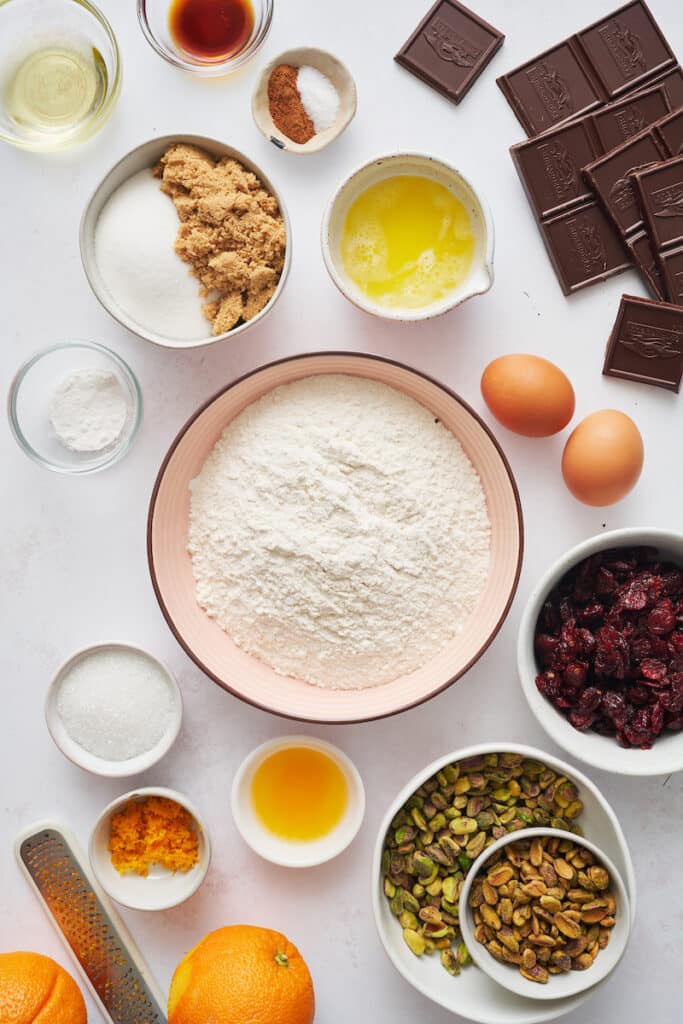 Ingredients for cranberry orange biscotti on a large white table. 