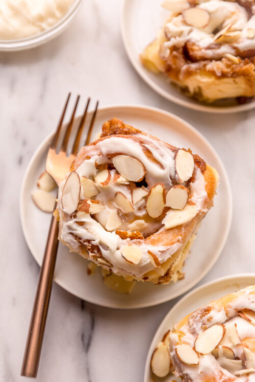 Triple Almond Cinnamon Rolls are the ultimate breakfast treat! This indulgent recipe features soft and fluffy yeasted buns that are filled with brown sugar cinnamon filling and topped with a sticky sweet glaze and slivered almonds! This homemade almond cinnamon roll recipe is a MUST for all of the almond lovers out there!