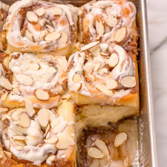 Triple Almond Cinnamon Rolls are the ultimate breakfast treat! This indulgent recipe features soft and fluffy yeasted buns that are filled with brown sugar cinnamon filling and topped with a sticky sweet glaze and slivered almonds! This homemade almond cinnamon roll recipe is a MUST for all of the almond lovers out there!