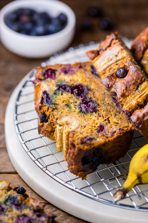 HOLY YUM! This Healthy Blueberry Banana Bread is moist, flavorful, and so delicious. Can't believe it's made with good-for-you ingredients.