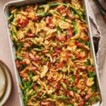 Baking dish with green bean casserole topped with crispy fried onions.