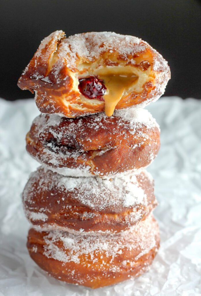 Bakery Style Peanut Butter and Jelly Doughnuts - Soft, fluffy, and stuffed with peanut butter and jelly - these bakery style doughnuts are a classic!