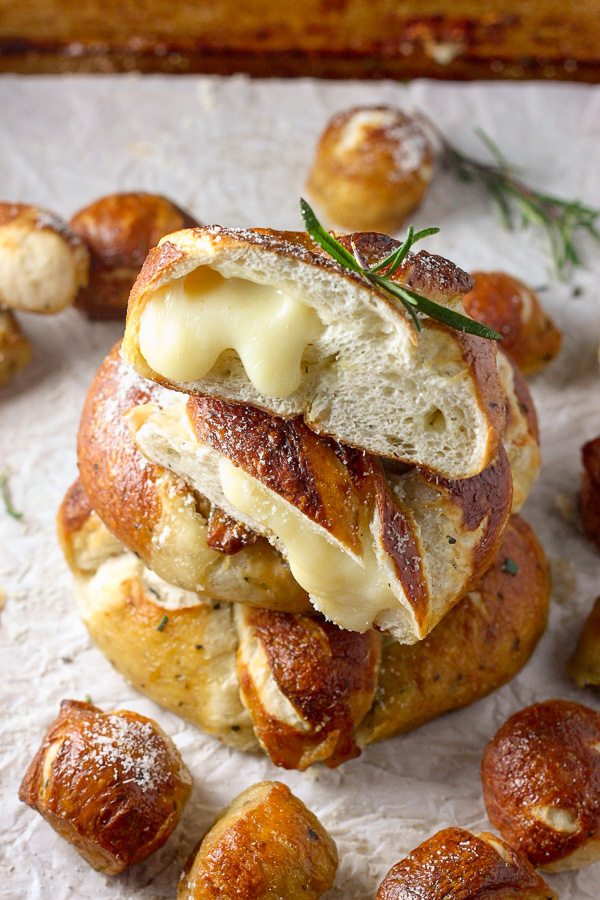 Mozzarella Stuffed Rosemary and Parmesan Soft Pretzels! Made with a simple soft pretzel dough and loaded with fresh herbs and Italian cheese. You're going to love these soft pretzels with cheese inside!