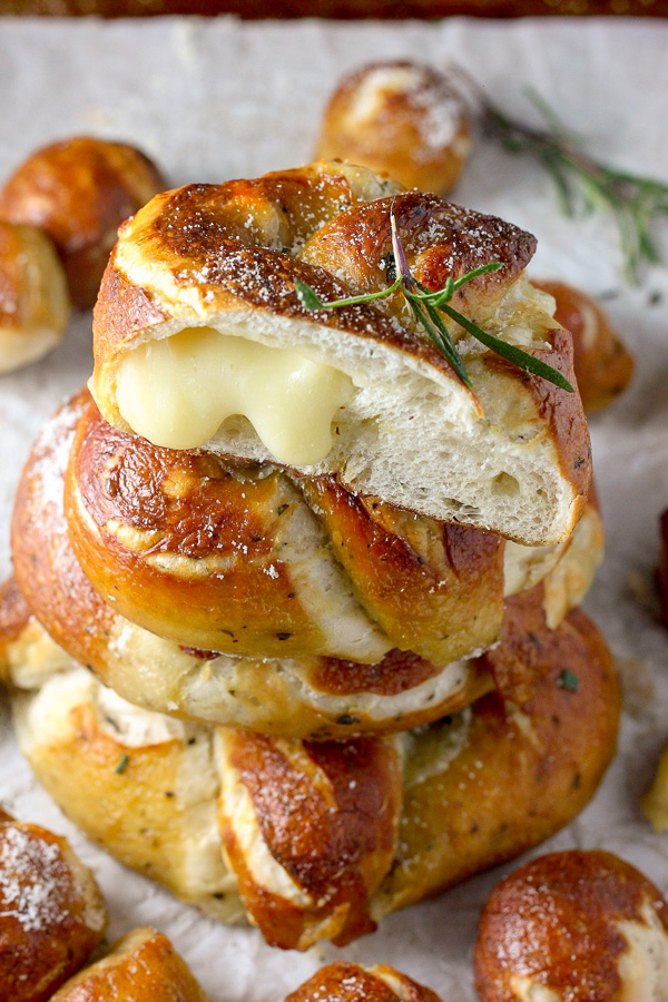 Mozzarella Stuffed Rosemary and Parmesan Soft Pretzels! Made with a simple soft pretzel dough and loaded with fresh herbs and Italian cheese. You're going to love these soft pretzels with cheese inside!