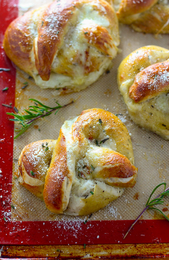 Mozzarella Stuffed Rosemary and Parmesan Soft Pretzels! Made with a simple soft pretzel dough and loaded with fresh herbs and Italian cheese. You're going to love these soft pretzels with cheese inside!