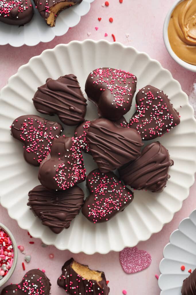 Chocolate covered peanut butter hearts on a white plate.