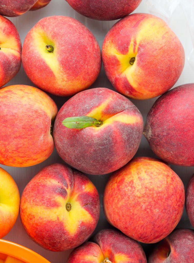 Soft and fluffy Fresh Peach Muffins are topped with a Creamy Cinnamon Vanilla Glaze! A delicious recipe sure to make you weak at the knees.