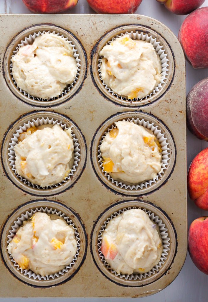 Soft and fluffy Fresh Peach Muffins are topped with a Creamy Cinnamon Vanilla Glaze! A delicious recipe sure to make you weak at the knees.