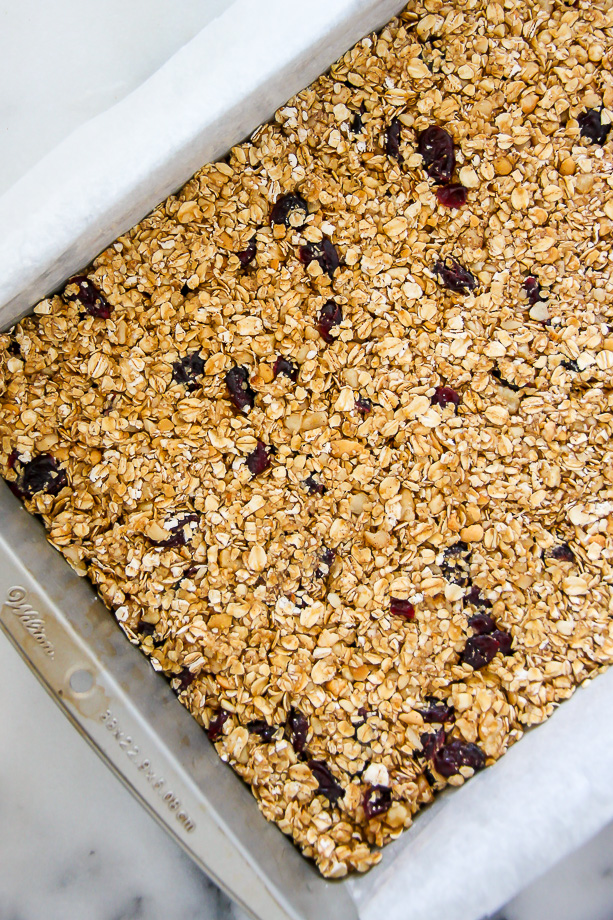 Loaded with cranberries, macadamia nuts, and topped with a sweet drizzle of white chocolate. These homemade granola bars are as easy as they are irresistible!