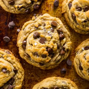 Vegan chocolate chip cookie recipe on a baking sheet with chocolate chips.