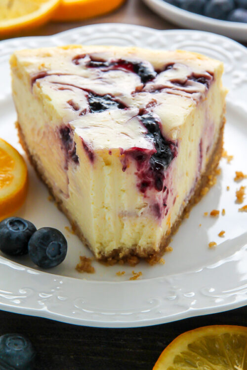Supremely smooth and creamy homemade Lemon cheesecake topped with fresh Blueberry swirls. All layered on top of a buttery homemade graham cracker crust.
