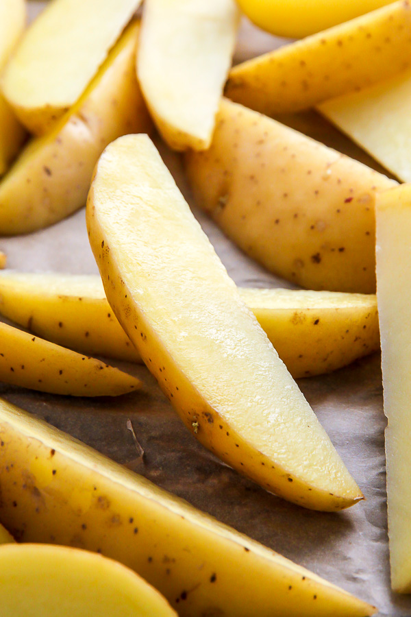 Extra crispy oven baked potato wedges flavored with garlic and herbs. Bet you can't eat just one!