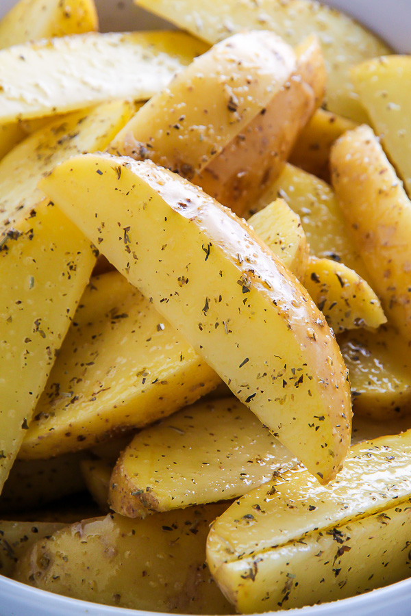 Extra crispy oven baked potato wedges flavored with garlic and herbs. Bet you can't eat just one!