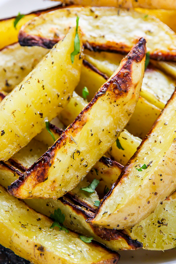 Extra crispy oven baked potato wedges flavored with garlic and herbs. Bet you can't eat just one!
