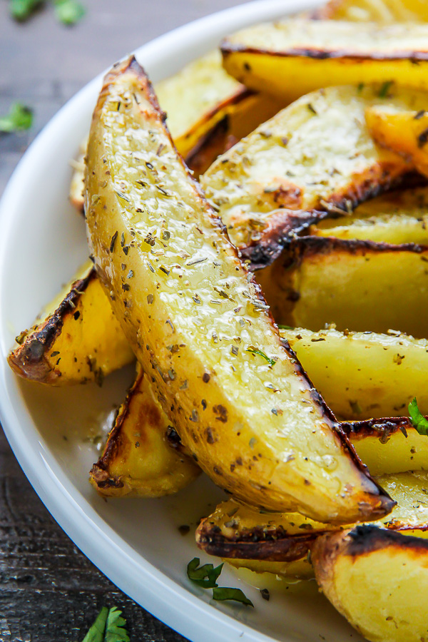 Extra crispy oven baked potato wedges flavored with garlic and herbs. Bet you can't eat just one!