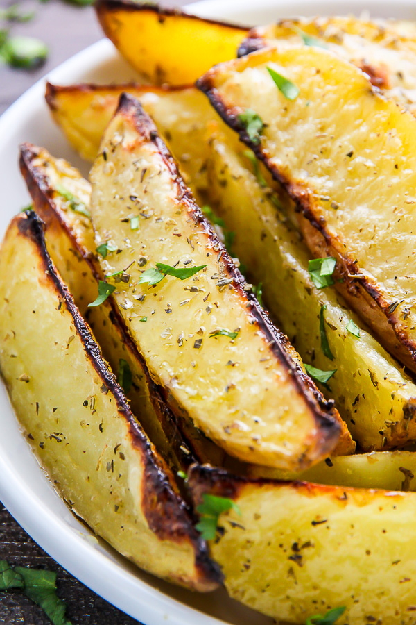 Extra crispy oven baked potato wedges flavored with garlic and herbs. Bet you can't eat just one!