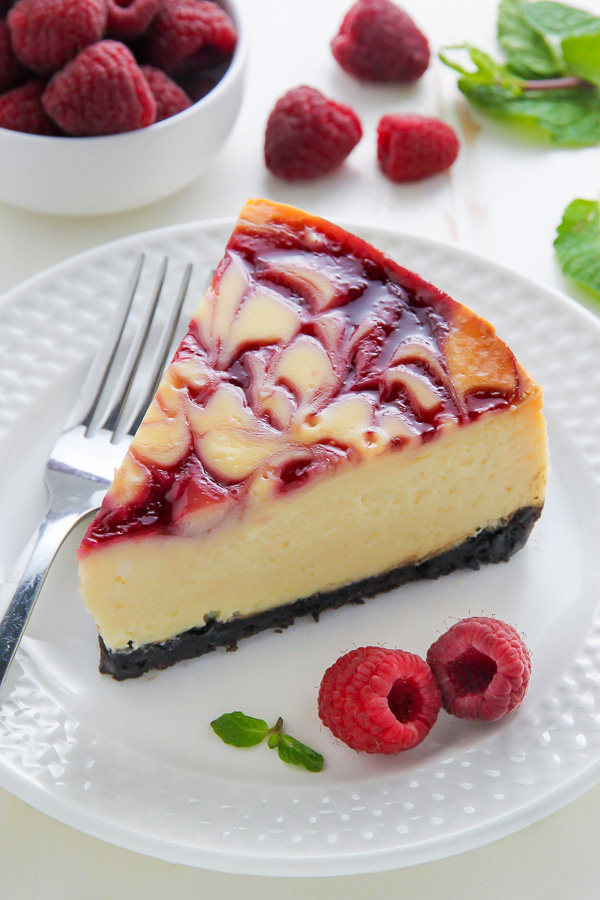 Creamy White Chocolate Cheesecake swirled with fresh raspberry, all on top of a homemade chocolate cookie crust. This one is a showstopper!