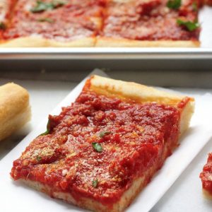 A slice of tomato pie on a paper towel.