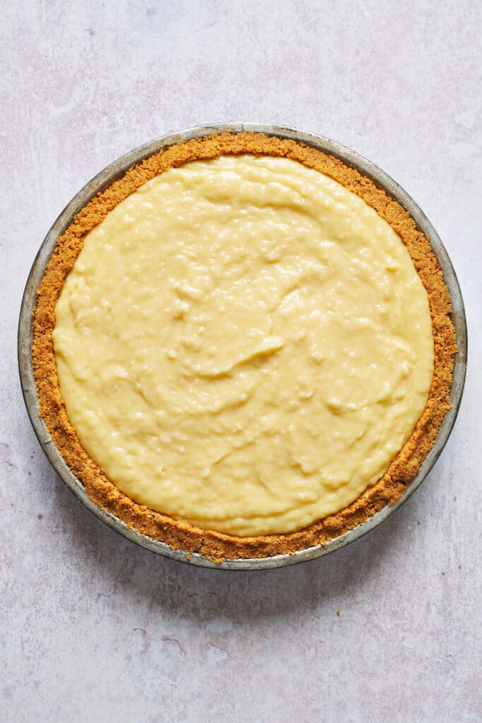 Graham cracker crust filled with creamy coconut filling for coconut cream pie recipe.