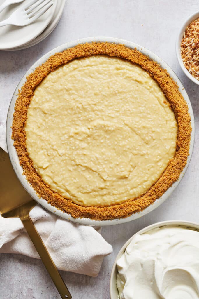 Graham cracker crust filled with creamy coconut filling for coconut cream pie recipe.