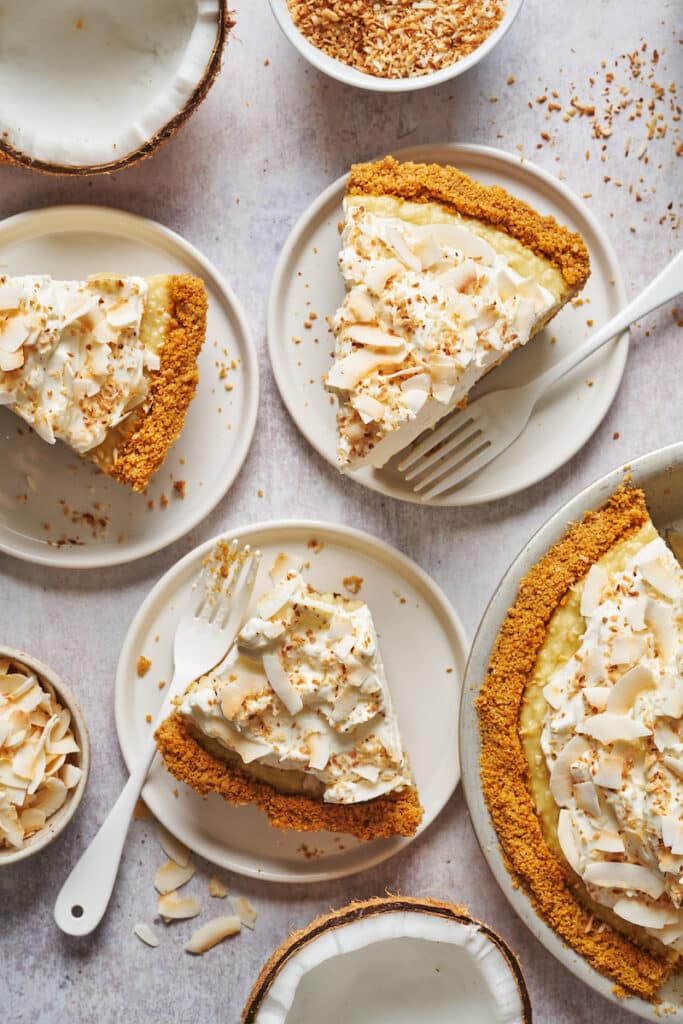 Slices of creamy coconut cream pie being lifted out of the pie plate.