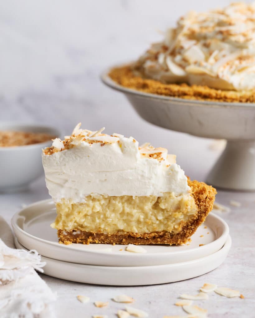 Slice of creamy coconut cream pie being lifted out of the pie plate.