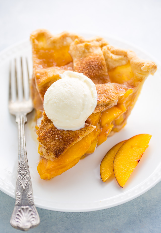 Slice of peach pie with vanilla ice cream on top.