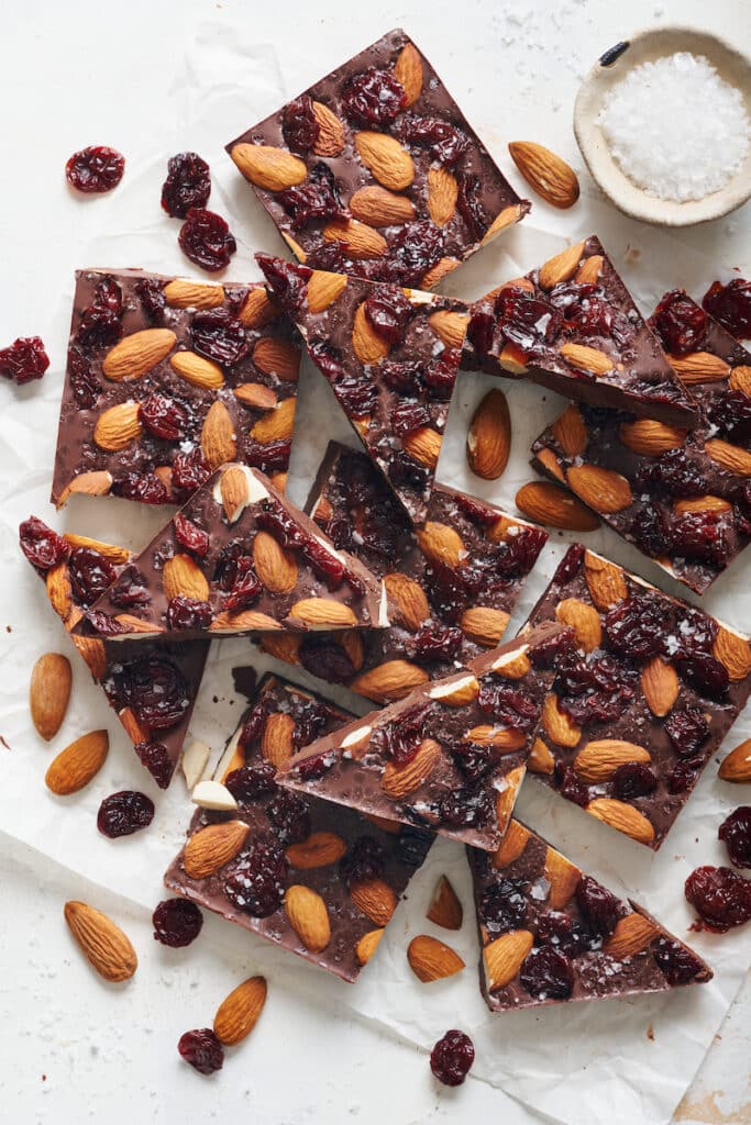 Dark chocolate bark chopped into squares with almonds and dried cherries on top.