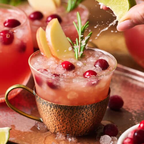 A cold copper mug filled with cranberry Moscow mules.