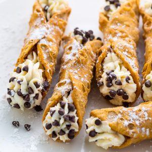 Cannoli with chocolate chips on a white plate.