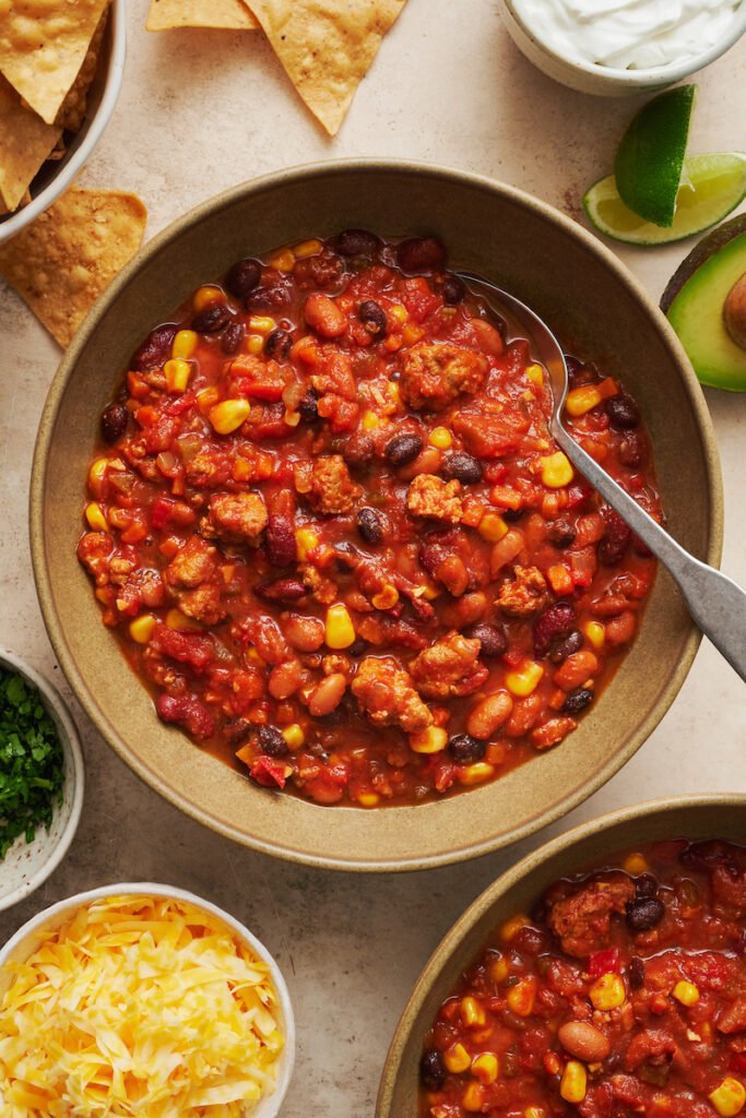 Bowl of turkey chili with a spoon in the bowl.