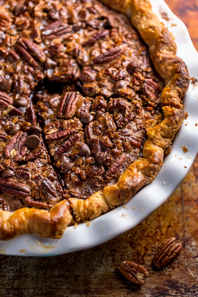 This insanely decadent Chocolate Pecan Pie is topped with a dollop of whipped cream... and extra chocolate, of course!