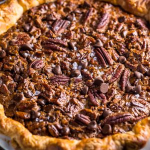 This insanely decadent Chocolate Pecan Pie is topped with a dollop of whipped cream... and extra chocolate, of course!