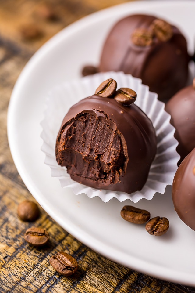 Chocolate truffle beside bulk measuring scoop with cocoa beans on