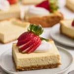 New York-Style Cheesecake Bars have a classic cheesecake filling and crunchy graham cracker crust! Full-fat cream cheese and sour cream are the secret to an ultra creamy cheesecake filling! Cut into squares and top with whipped cream and strawberries for a crowd-pleasing dessert everyone will love. 