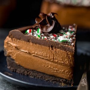 This No-Bake Peppermint Mocha Cheesecake is rich, creamy, and so flavorful! Topped with chocolate ganache and crushed candy canes, this chocolate peppermint cheesecake is seriously festive and perfect for holiday celebrations. #peppermintmocha #cheesecake #chocolate #Christmas #peppermint