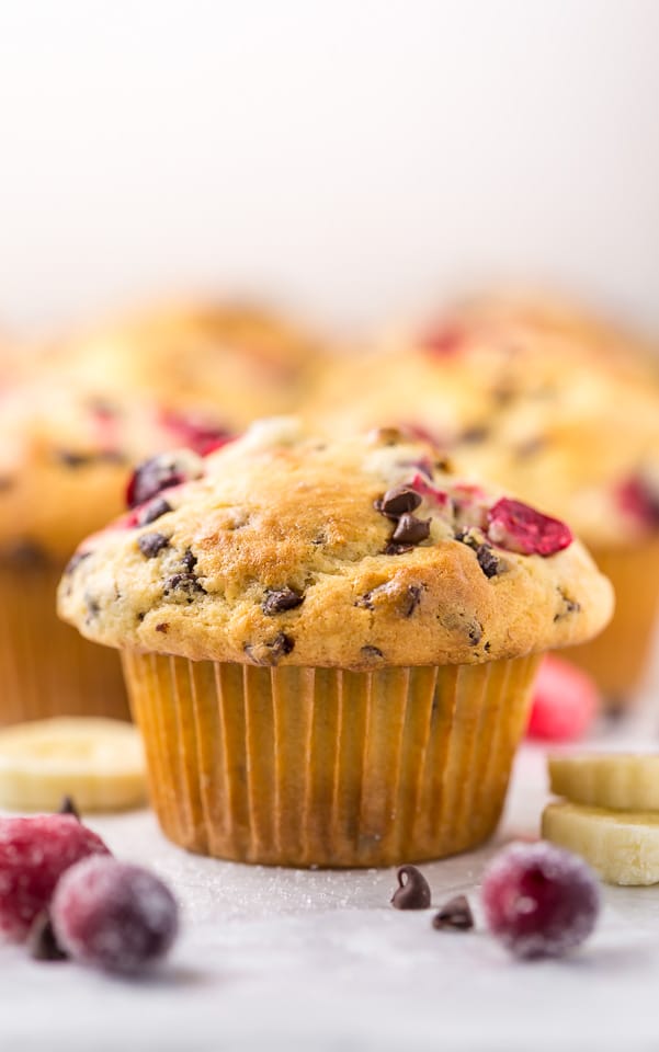 These soft and fluffy Cranberry Banana Muffins are so easy and perfect for breakfast! Full of real banana flavor, fresh cranberries, and a handful of chocolate chips, they're simply irresistible! #cranberry #banana #muffins #breakfast #Christmas #bananamuffins #chocolatechips