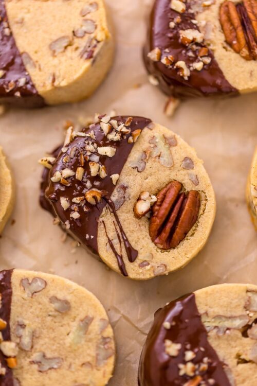 These delicious Butter Pecan Slice and Bake Cookies are so easy and made with just 7 ingredients! These buttery shortbread cookies are loaded with crunchy pecans and then dunked in sweet chocolate. These cookies are so good with a cup of coffee or tea!