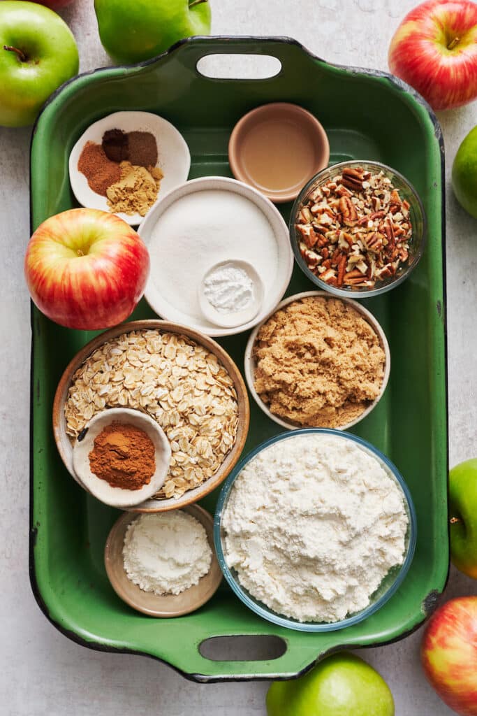 Ingredients for homemade apple crisp in a green baking dish.