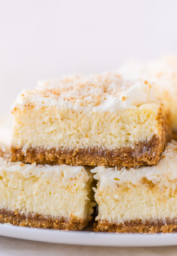 These Coconut Cheesecake Bars are creamy, sweet, and loaded with real coconut in every bite! Baked in cake pan and no water bath required, this recipe is easy and delicious! This family friendly recipe is always a crowd pleaser.