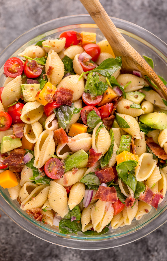 This Creamy Avocado BLT Pasta Salad is so easy and perfect for Summer celebrations! Loaded with crispy bacon, juicy tomatoes, spinach, avocado, and cheddar cheese. This flavorful pasta salad is always a crowd-pleaser!