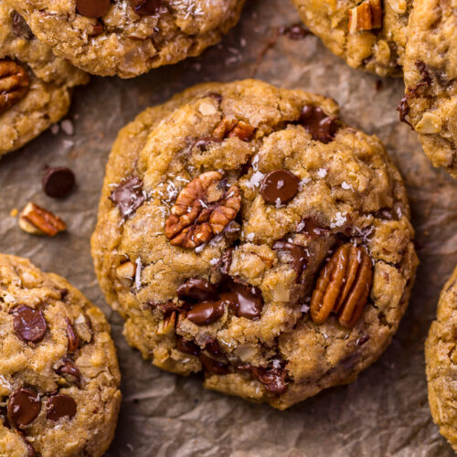 Cowboy cookies on a parchment paper lined baking sheet.