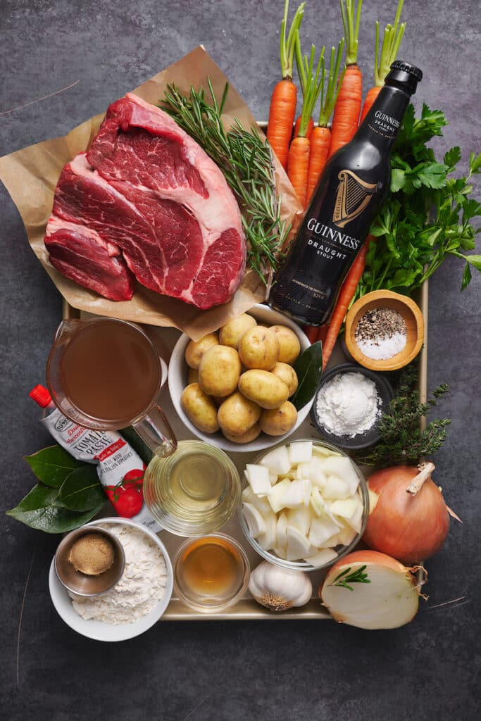 Ingredients for Guinness beef stew on a baking sheet.