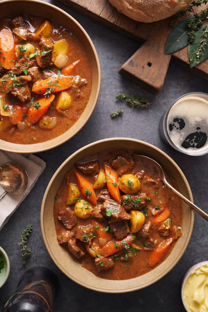 Beef stew in bowls with Guinness beer on the side.