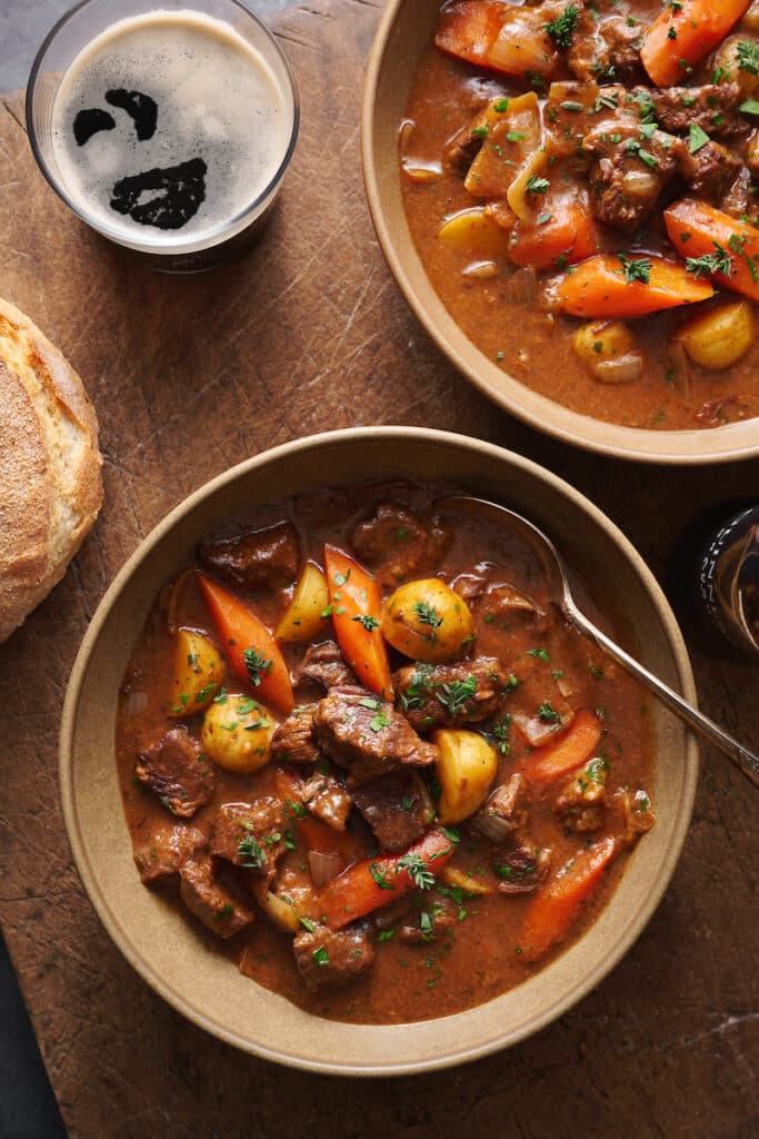 Bowl of Guinness beef stew with a Guinness beer on the side. 